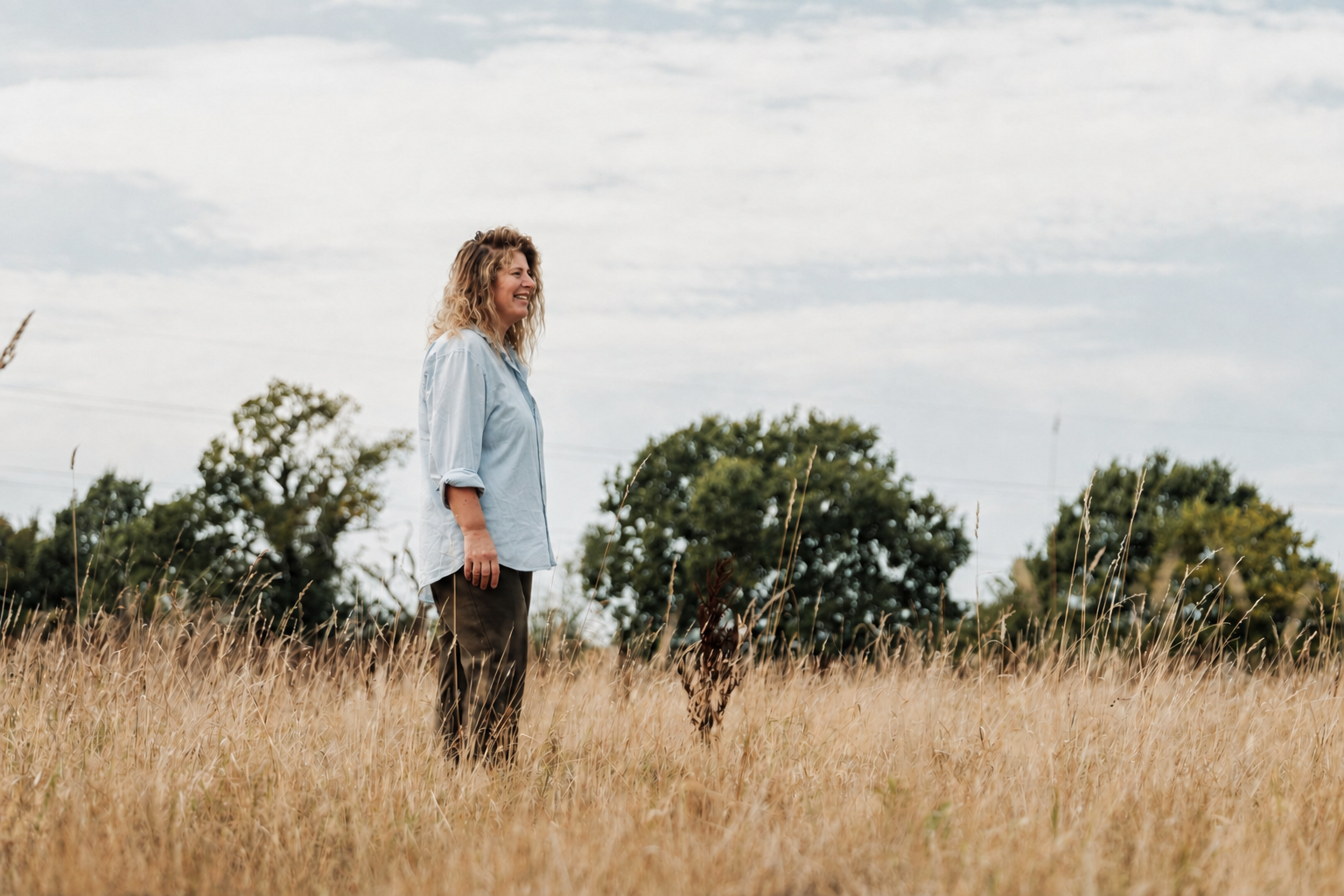 Laura standing in a golden meadow near Canterbury